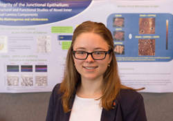 Sofia Kholmogorova posing in front of their poster